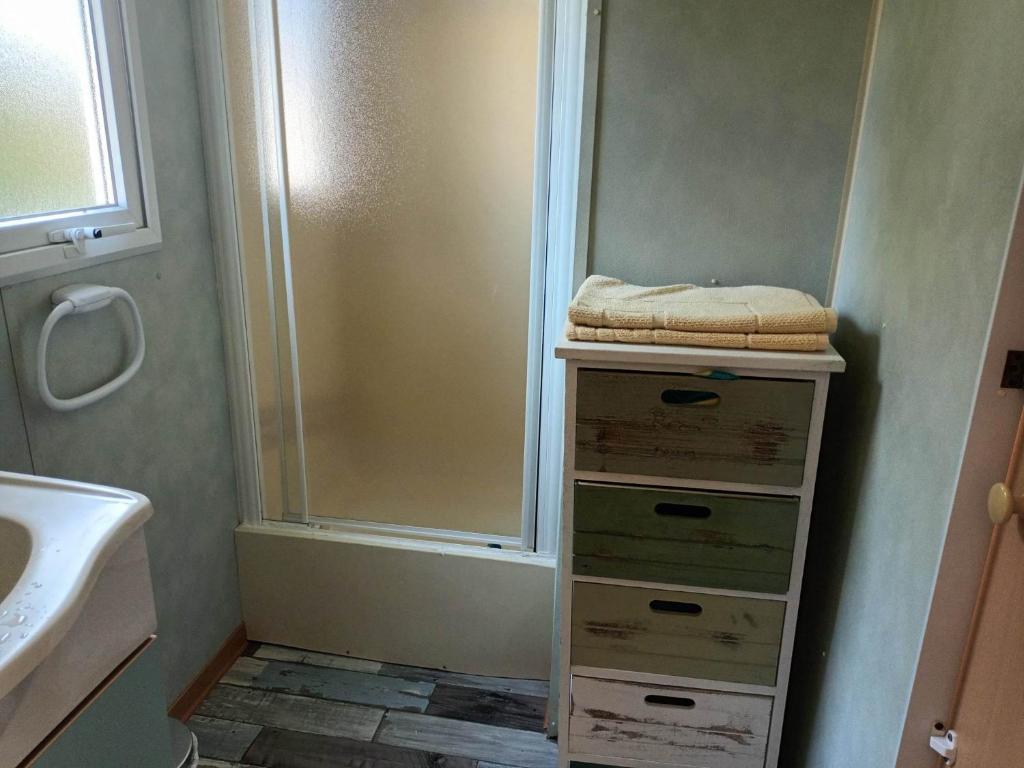- une salle de bains avec une pile de boîtes à côté d'un lavabo dans l'établissement Mobil-home gorges du verdon lac de sainte croix camping poney, à Sainte-Croix-de-Verdon