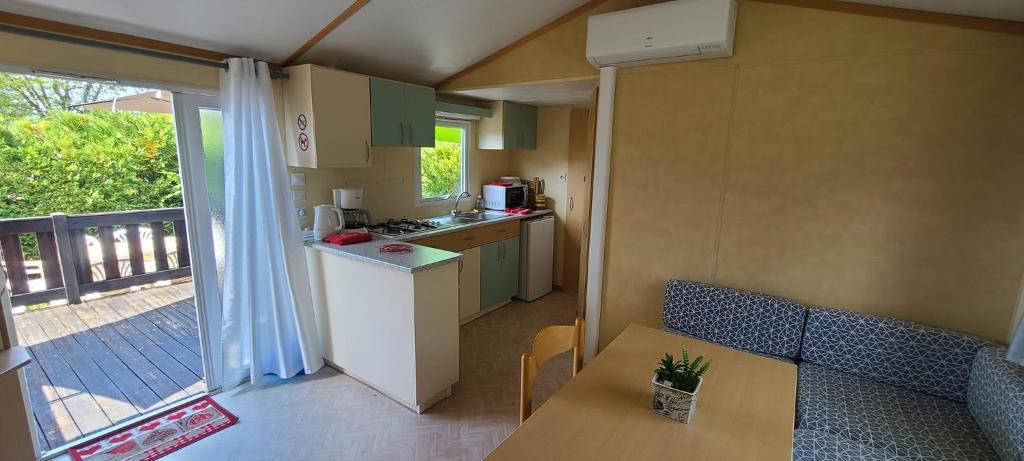 - une petite cuisine avec une table et un comptoir dans l'établissement Mobil-home gorges du verdon lac de sainte croix camping poney, à Sainte-Croix-de-Verdon