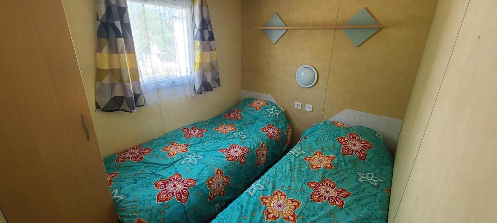 une petite chambre avec un lit et une fenêtre dans l'établissement Mobil-home gorges du verdon lac de sainte croix camping poney, à Sainte-Croix-de-Verdon