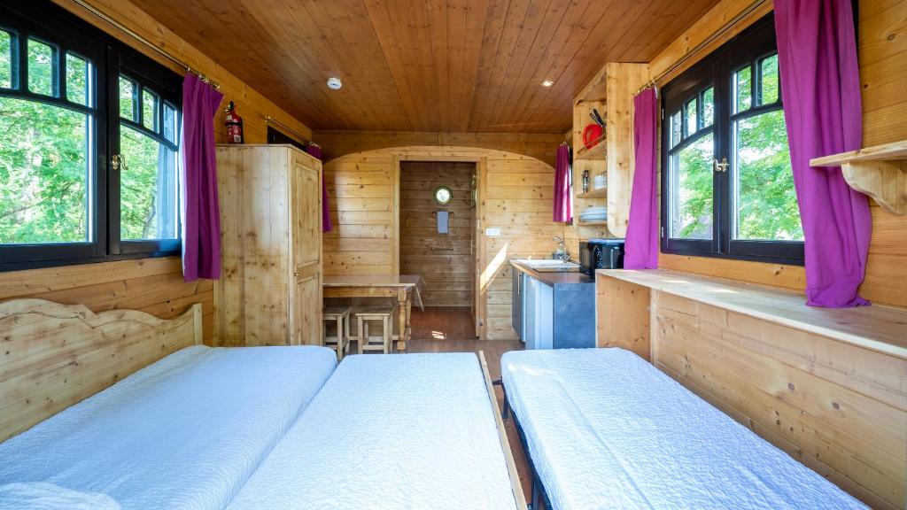 une chambre avec deux lits et une cuisine dans une cabine dans l'établissement Village Toue du Domaine des Demoiselles, à Chassenard 37 autres photos