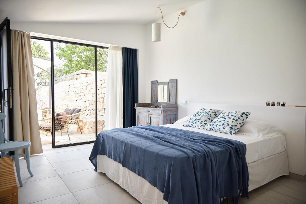 une chambre avec un lit et une grande fenêtre dans l'établissement Dimora del Carrubo, à Polignano a Mare