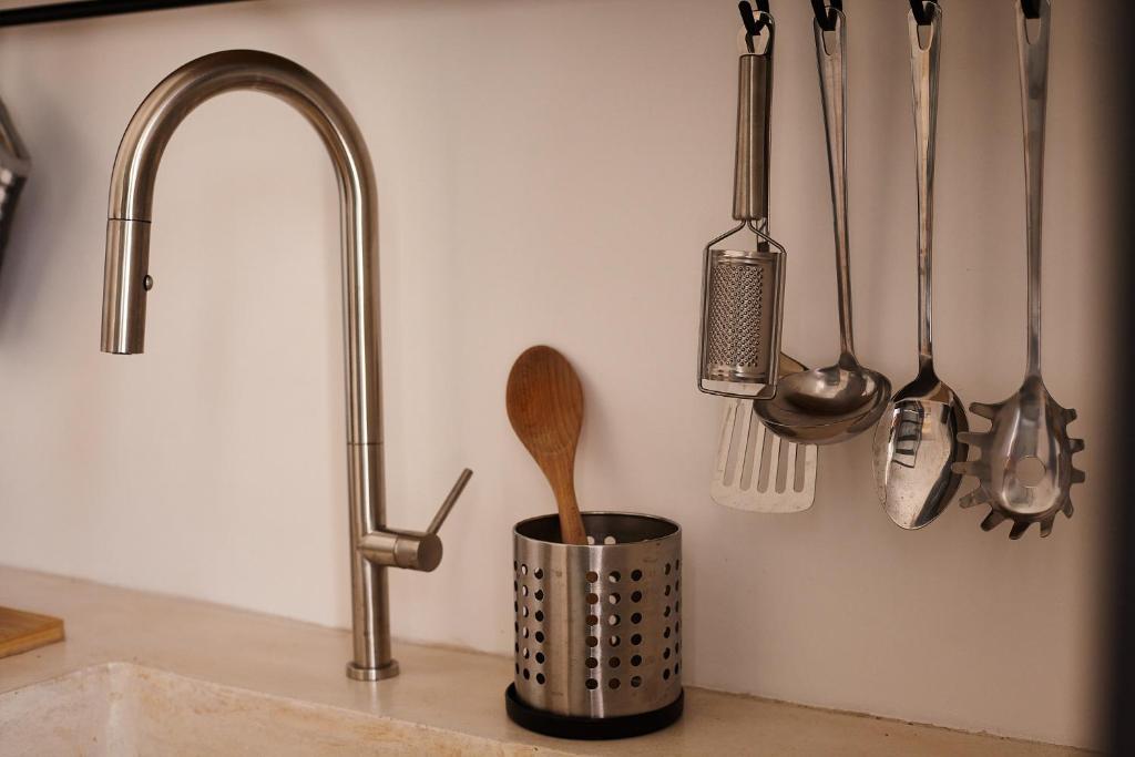 - un comptoir de cuisine avec évier et ustensiles sur un mur dans l'établissement Dimora del Carrubo, à Polignano a Mare 39 autres photos