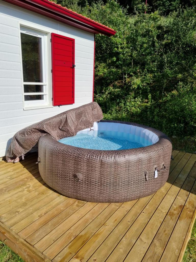 - un bain à remous sur une terrasse avec une cabane pour chiens dans l'établissement Chalet Etxetxoa, de 1 à 4 personnes avec Climatisation, SPA, Terrain privé et Piscine, à Hasparren