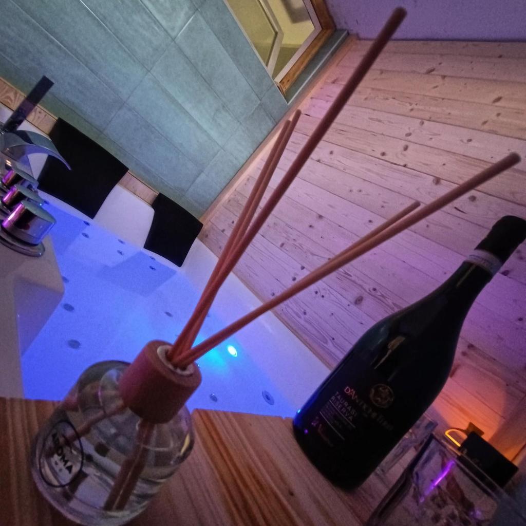 une bouteille de vin et un verre sur une table dans l'établissement SUITTINA, exclusive - wellness - living, à Battipaglia