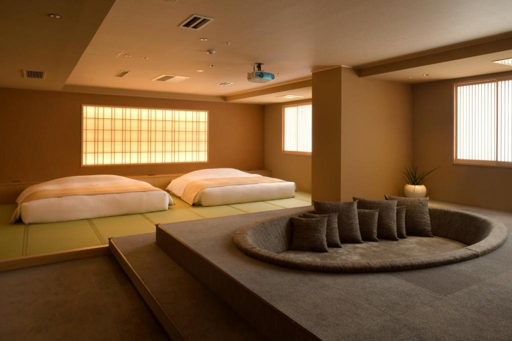 - 2 lits dans une grande chambre avec un tapis dans l'établissement Suigan, à Jozankei