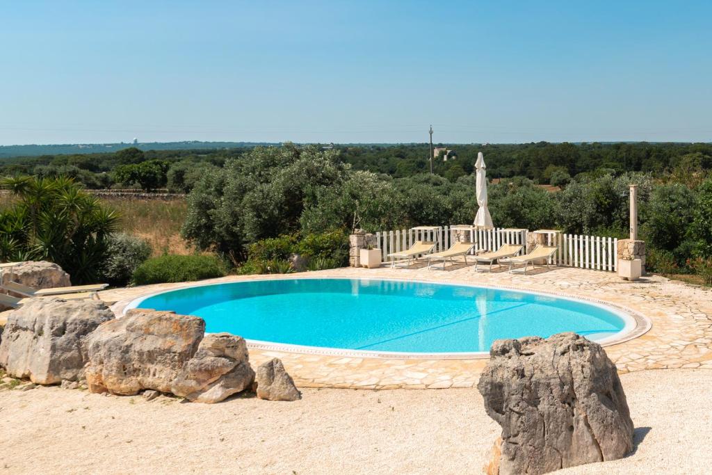 une piscine avec des rochers devant dans l'établissement Trullo Alba, à Martina Franca