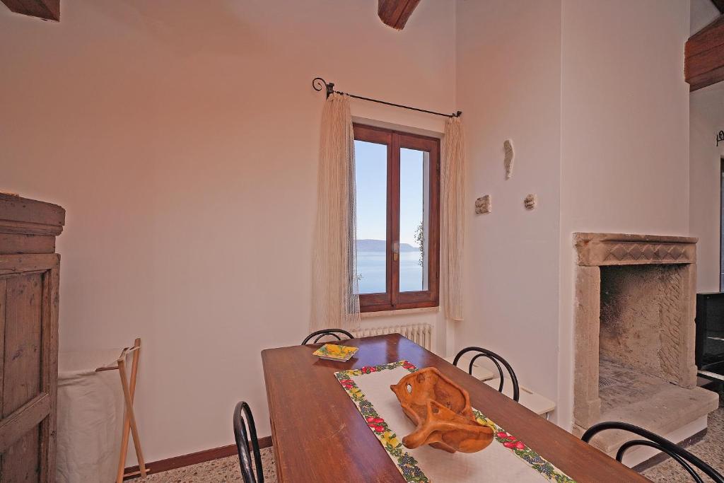 une salle à manger avec une table et une fenêtre dans l'établissement Ville in uliveto vista lago - VILLA CASALIVA, à Pulciano