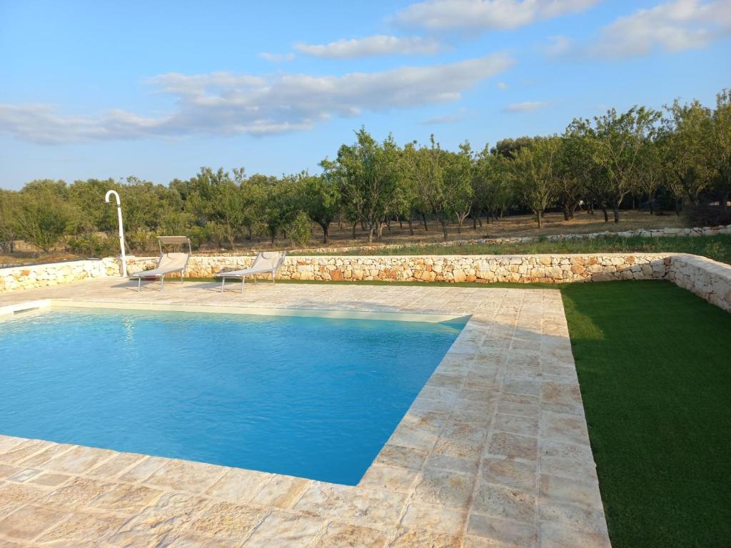 - une piscine dans une cour dotée d'un mur en pierre dans l'établissement Villa Molillo, à Ostuni