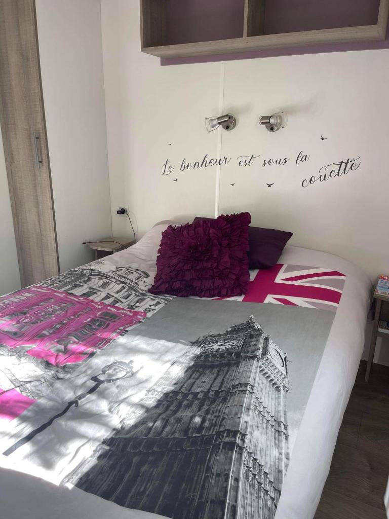 - une chambre avec un lit et un bureau sur le mur dans l'établissement Mobilhome ´Sandra ´, à Lagorce