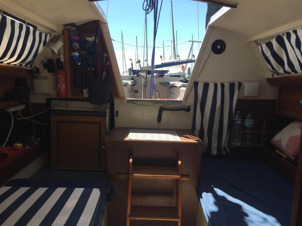 une petite chambre avec une échelle et une table dans un bateau dans l'établissement Petit voilier à quai Port Barcares, au Barcarès