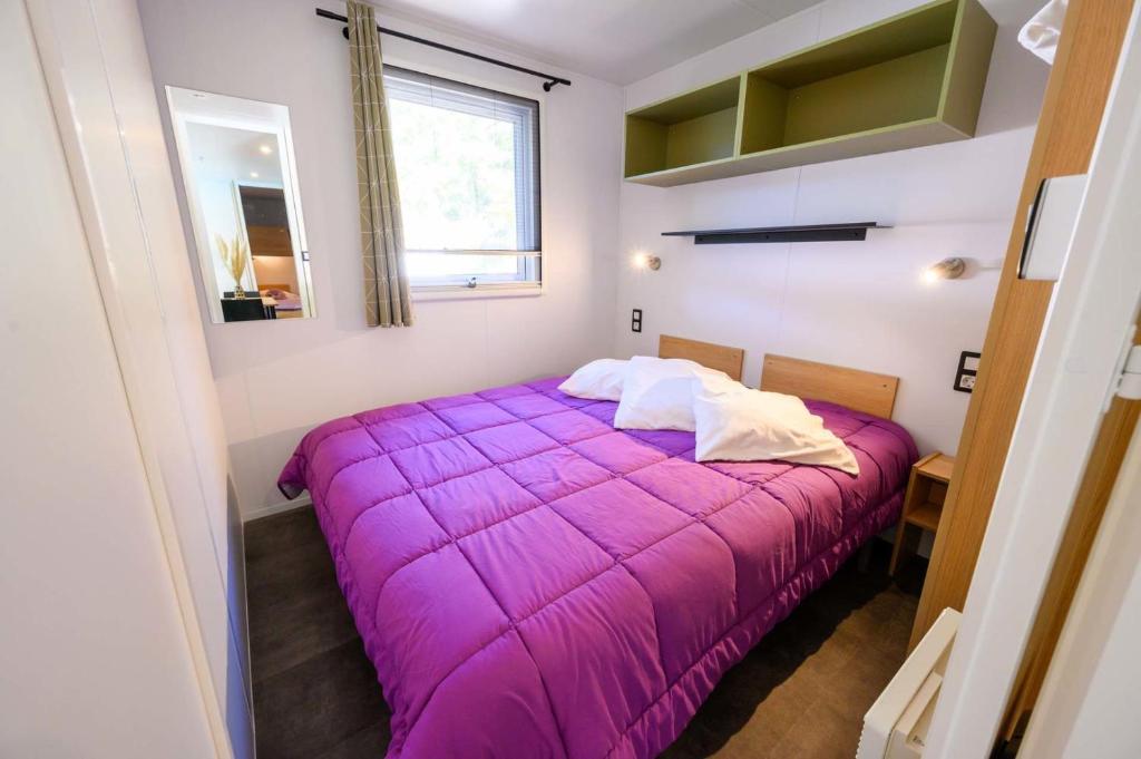 - un lit violet dans une petite chambre avec fenêtre dans l'établissement Le Clos de Barbey, à Bauduen 37 autres photos