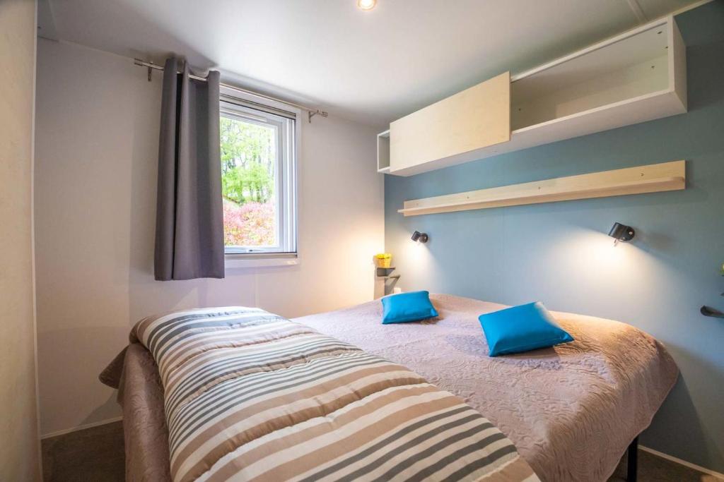une chambre avec un lit avec des oreillers bleus dessus dans l'établissement Le Clos de Barbey, à Bauduen