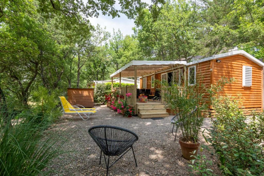 une cabane en rondins avec un banc et une chaise dans l'établissement Le Clos de Barbey, à Bauduen