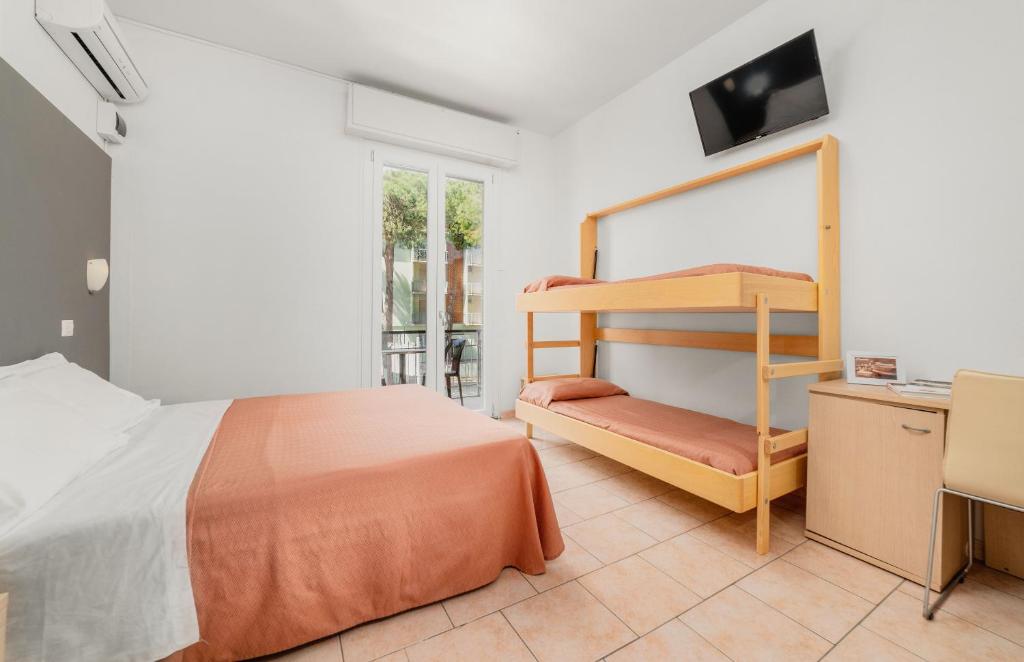 une chambre avec un lit superposé et un bureau dans l'établissement HOTEL OLIVER, à Cervia