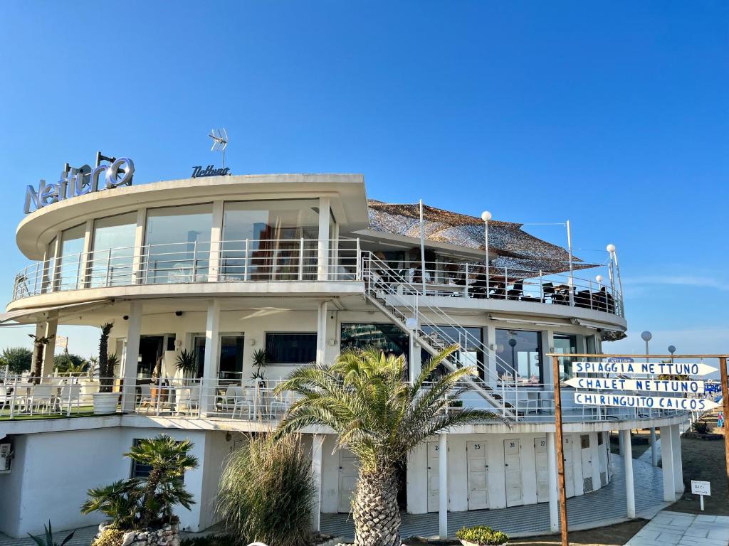 - un grand bâtiment blanc avec des personnes sur le balcon dans l'établissement Hotel Columbia Frontemare, à Rimini