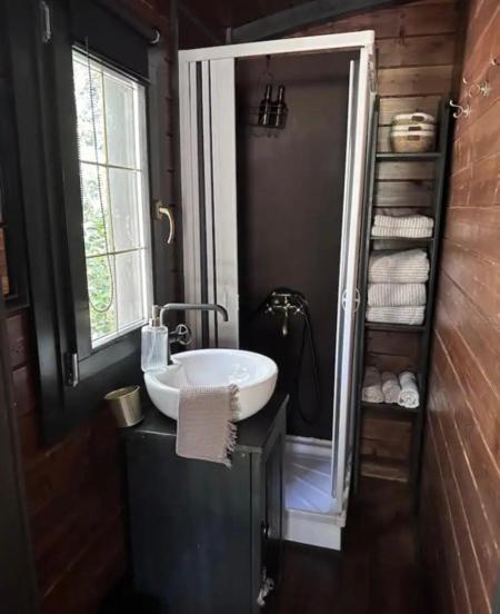 une salle de bain avec un lavabo blanc et une fenêtre dans l'établissement Roulotte / Tiny House dans les Alpilles, à Saint-Rémy-de-Provence
