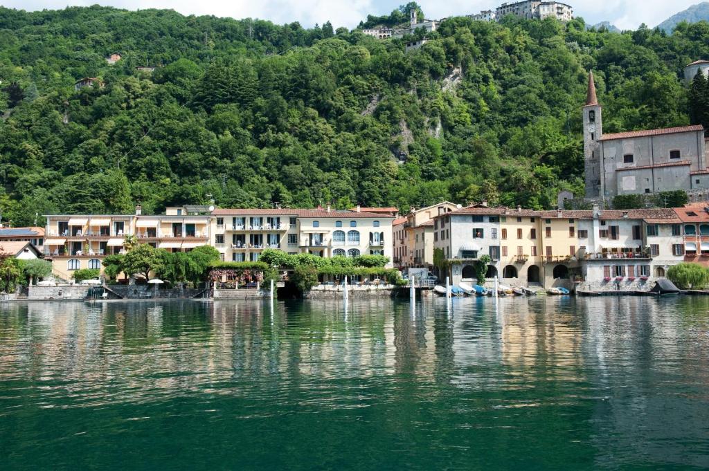 un groupe de bâtiments sur une masse d'eau dans l'établissement Hotel Stella D'Italia, à Valsolda 9 autres photos