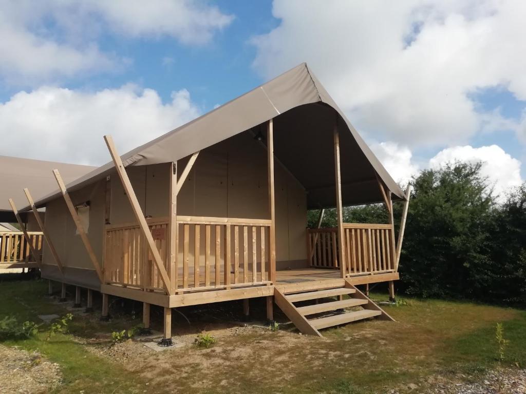 une grande tente avec une terrasse dans un champ dans l'établissement UCPA Eco Lodge, à Séné