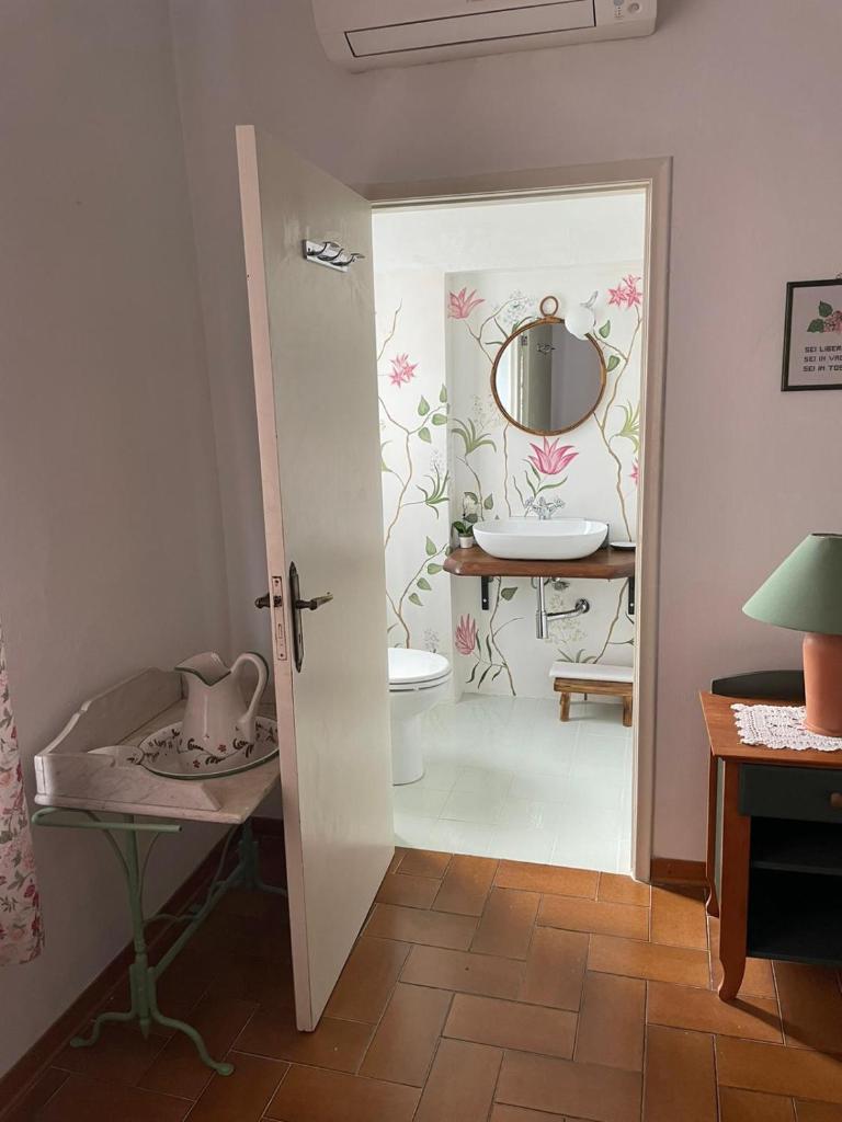 une salle de bain avec toilettes et miroir dans l'établissement Villa Remignoli, à San Gimignano