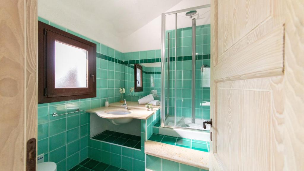 La salle de bains est pourvue de carrelage vert, d'un lavabo et d'une douche. dans l'établissement VILLA ISA 6, Emma Villas, à Palau