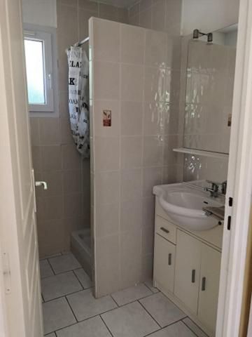 une salle de bain blanche avec un lavabo et une douche dans l'établissement CAMPING HERMITAGE DES 4 SAISONS, à Saint-Julien-de-Bourdeilles