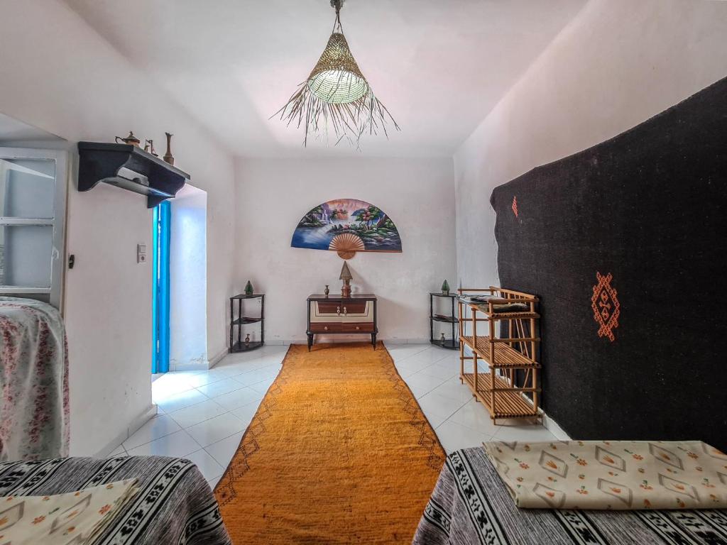 une pièce avec un lit et une table dedans dans l'établissement Riad MIYA, à Essaouira