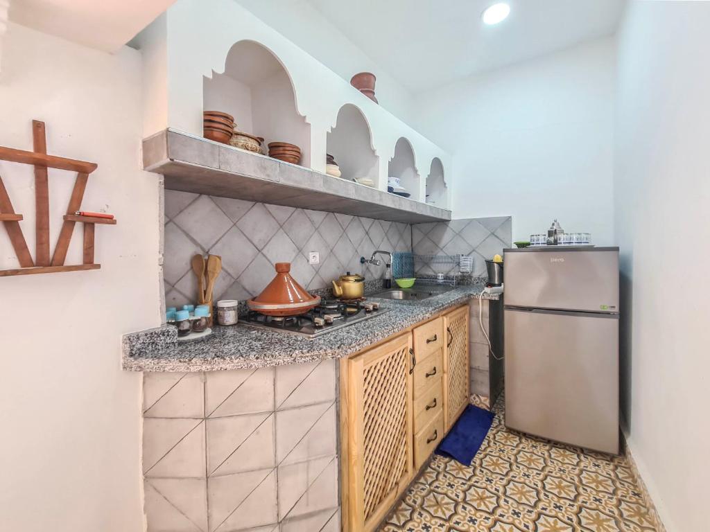une cuisine avec une cuisinière et un réfrigérateur dans l'établissement Riad MIYA, à Essaouira