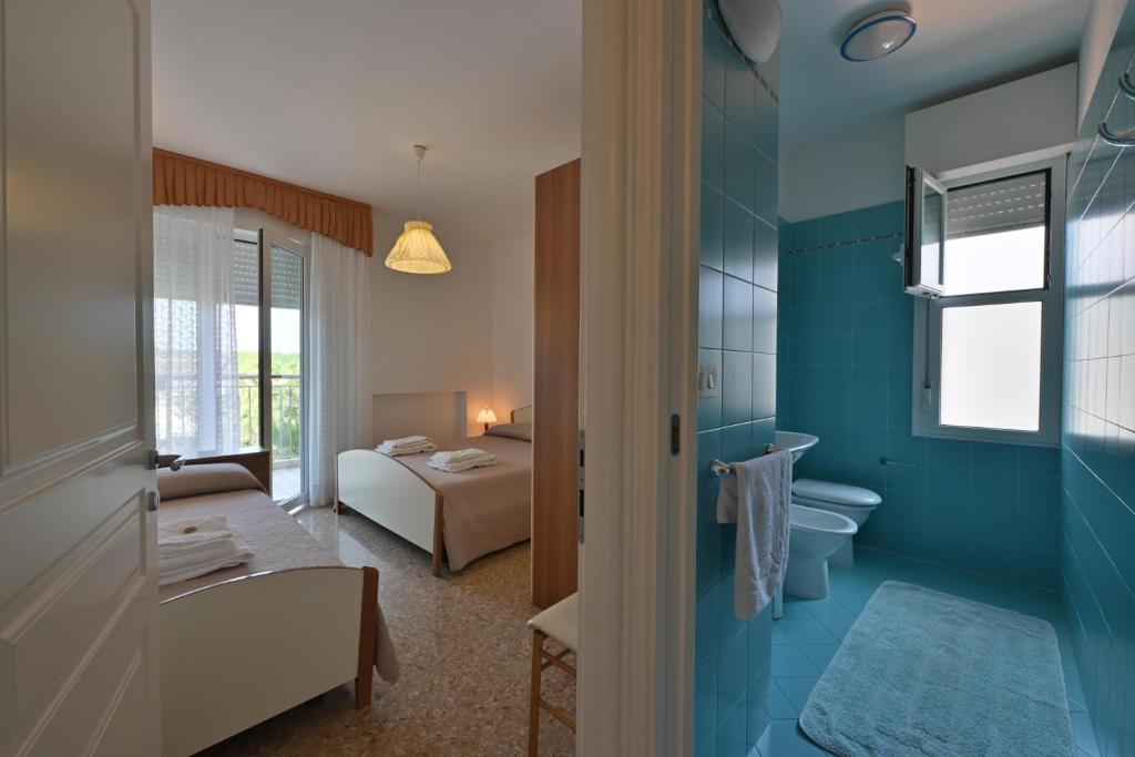 La salle de bains est pourvue d'une chambre avec un lit et des toilettes. dans l'établissement Residence Mariavittoria, à Lido di Jesolo