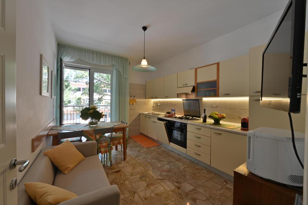 une cuisine et un salon avec un canapé et une table dans l'établissement Residence Mariavittoria, à Lido di Jesolo