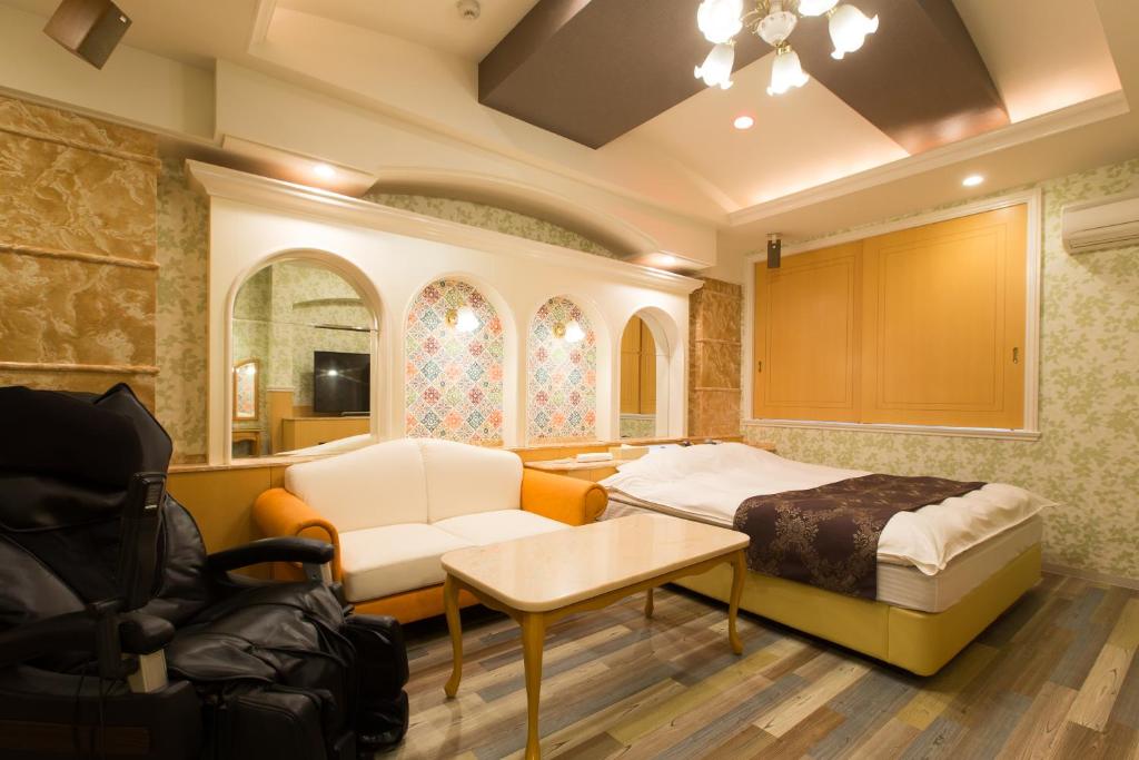 une chambre avec un lit, un canapé et une table dans l'établissement ホテルシエル沼津店 沼津インター -大人専用-, à Numazu