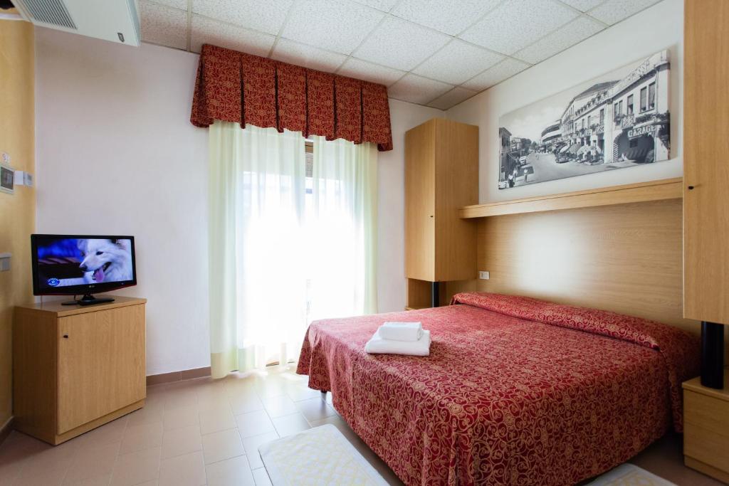 - une chambre avec un lit rouge et une télévision dans l'établissement Hotel Al Mare, à Lido di Jesolo 73 autres photos
