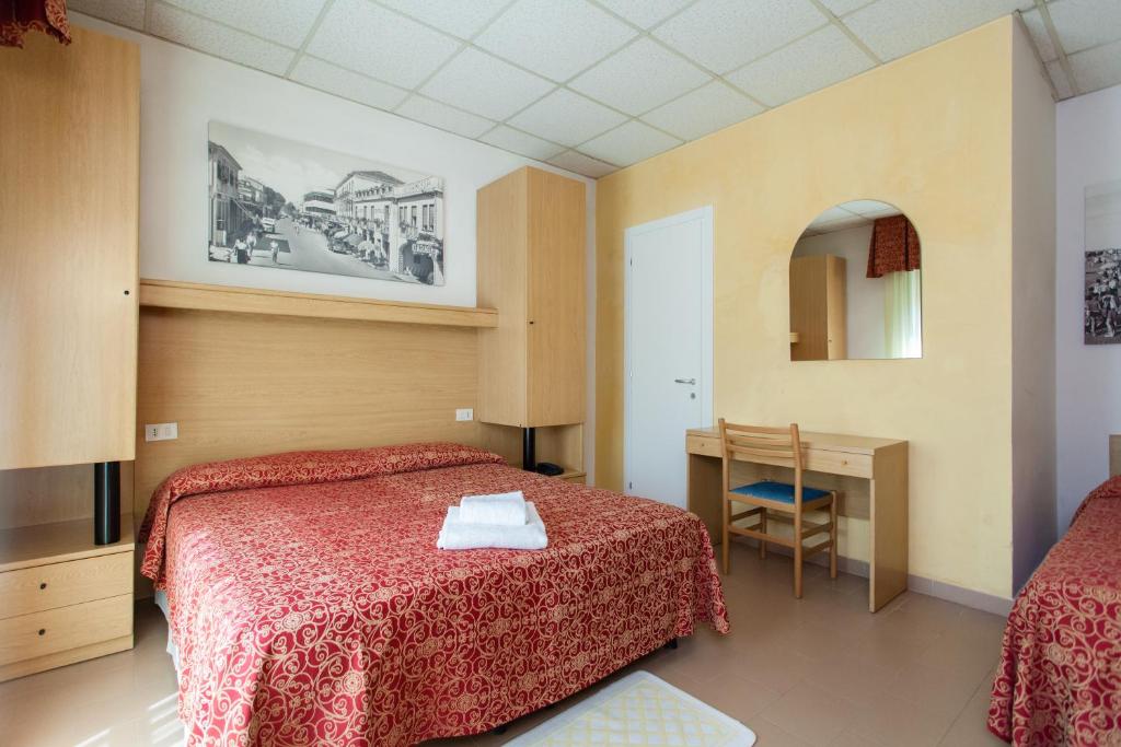une chambre avec un lit, une table et un miroir dans l'établissement Hotel Al Mare, à Lido di Jesolo