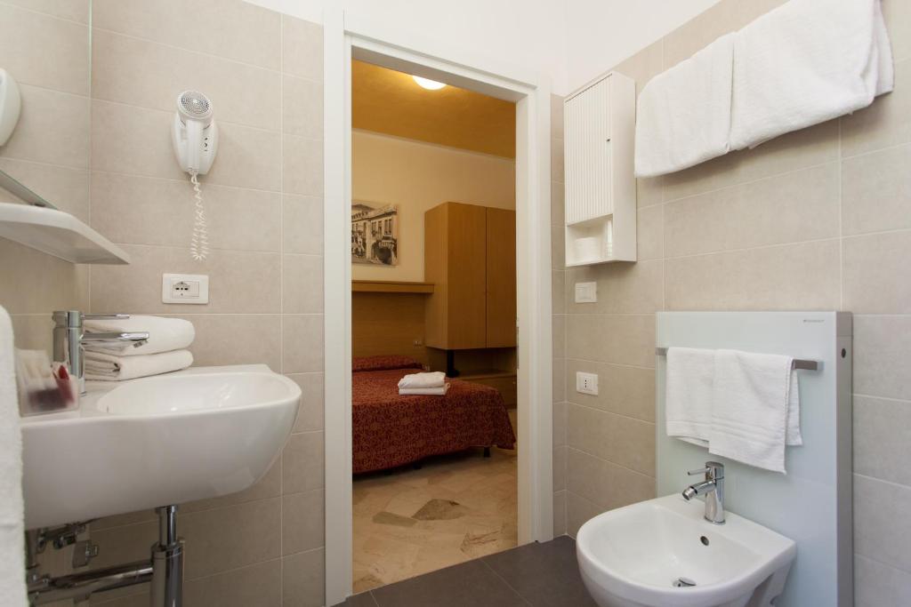 une salle de bain avec un lavabo et des toilettes dans une chambre dans l'établissement Hotel Al Mare, à Lido di Jesolo