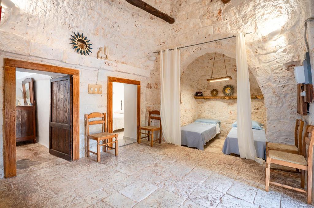 une chambre avec un lit, une table et des chaises dans l'établissement Trullo Nonno Vittorio, à Latiano