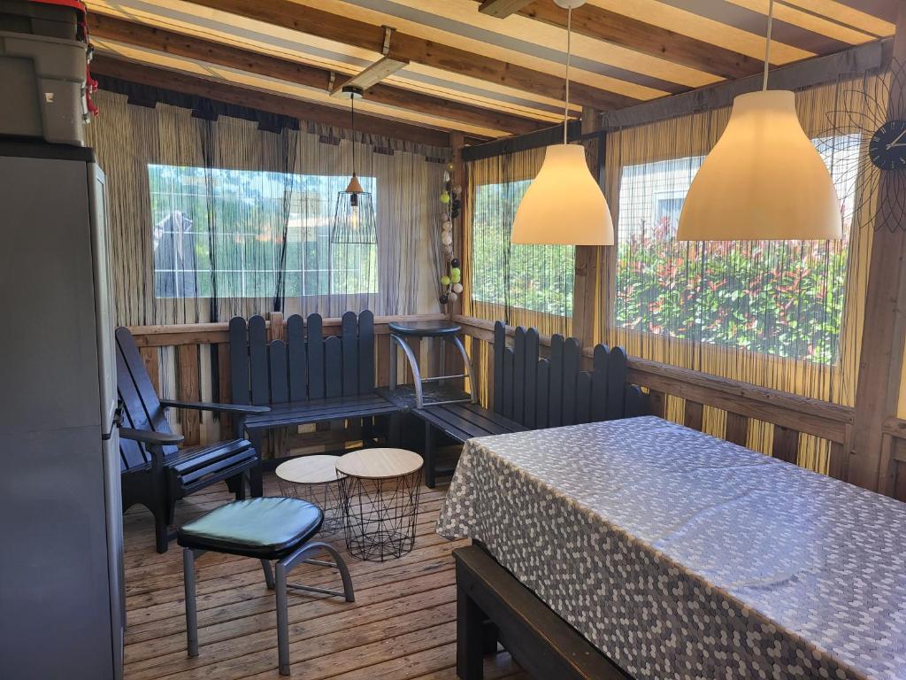 une salle à manger avec une table, des chaises et des fenêtres dans l'établissement Sevservices à La Réserve, à Gastes