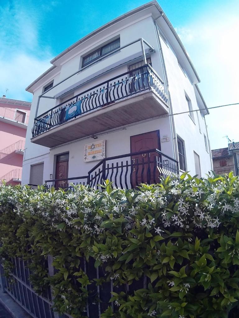 un bâtiment blanc avec un balcon et quelques buissons dans l'établissement Birilli B&B, à Civitanova Marche