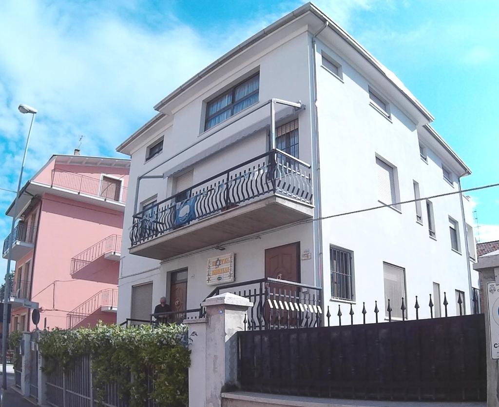 une maison blanche avec un balcon et une clôture dans l'établissement Birilli B&B, à Civitanova Marche 76 autres photos