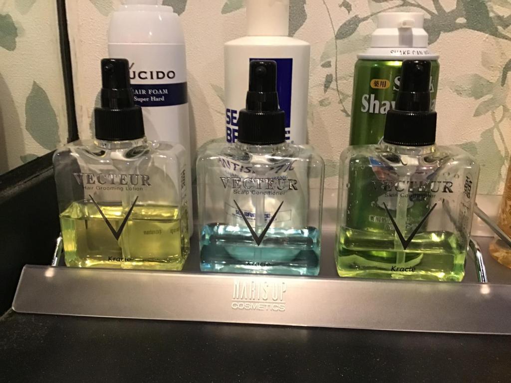trois bouteilles de savon et de shampoing sur une étagère dans l'établissement Hotel Valentine (Adult Only)/Vacation STAY　A館, à Tottori