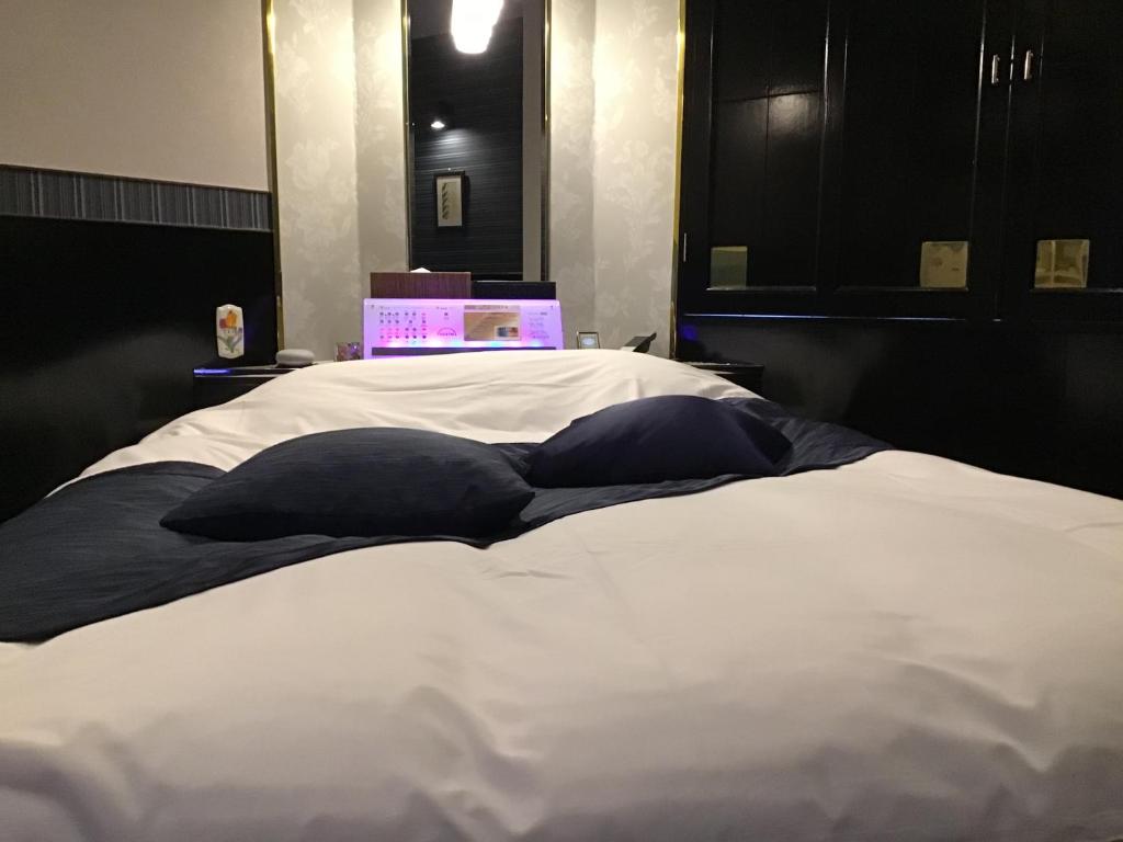 une chambre avec un lit avec un ordinateur portable dessus dans l'établissement Hotel Valentine (Adult Only)/Vacation STAY　A館, à Tottori