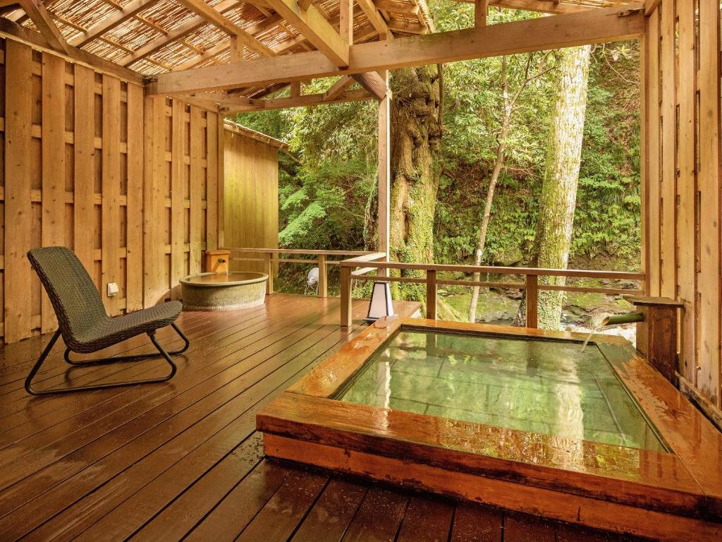 - une véranda avec une chaise sur le parquet dans l'établissement Mizumari, à Kawazu