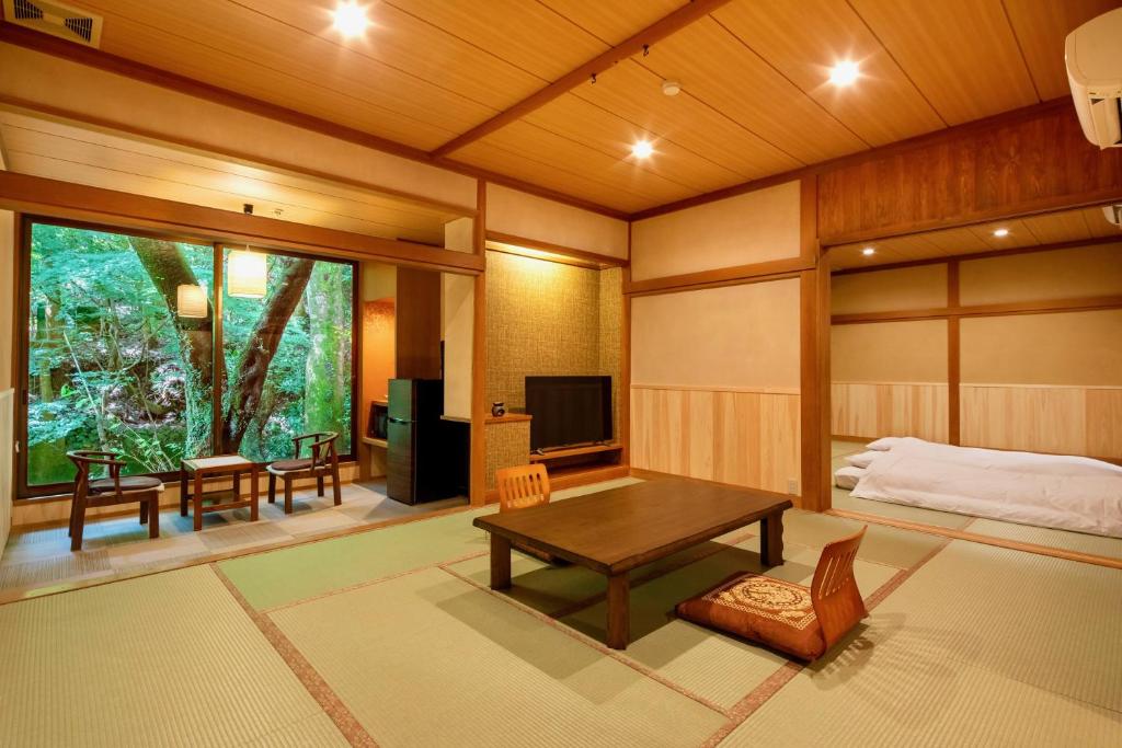 un salon avec une table et un lit dans l'établissement Mizumari, à Kawazu