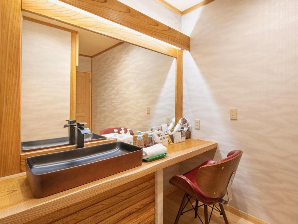 une salle de bain avec un lavabo et un miroir dans l'établissement Mizumari, à Kawazu 37 autres photos