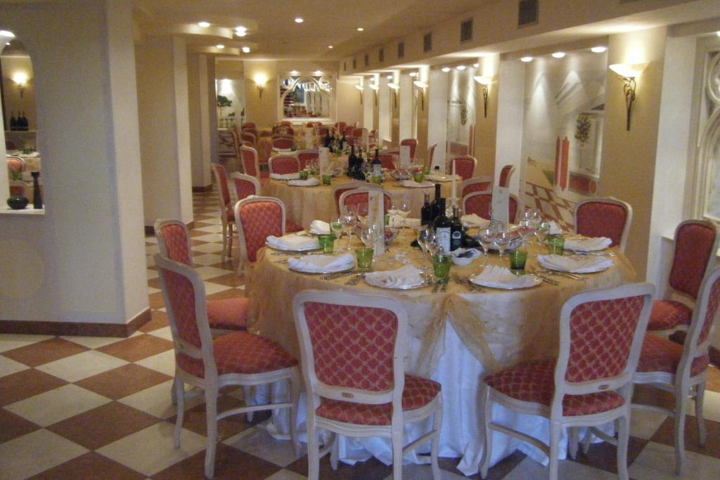 une salle à manger avec une longue table et des chaises dans l'établissement Hotel Real, à Sottomarina