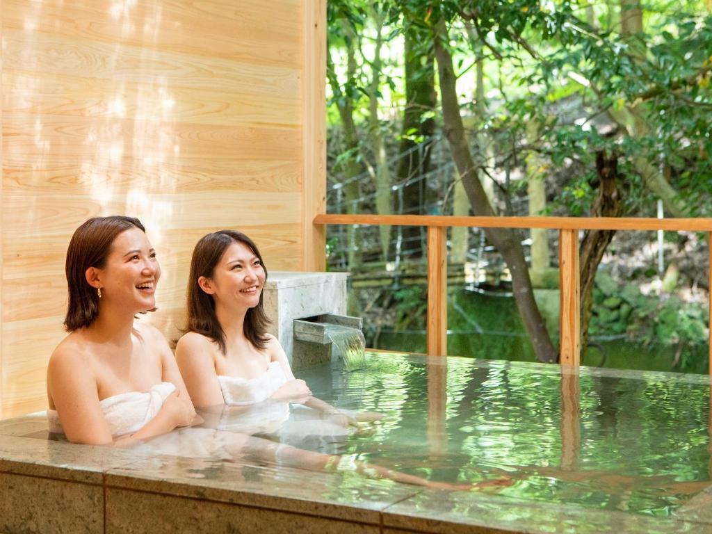 2 femmes assises dans un bain à remous dans l'établissement Mizumari, à Kawazu
