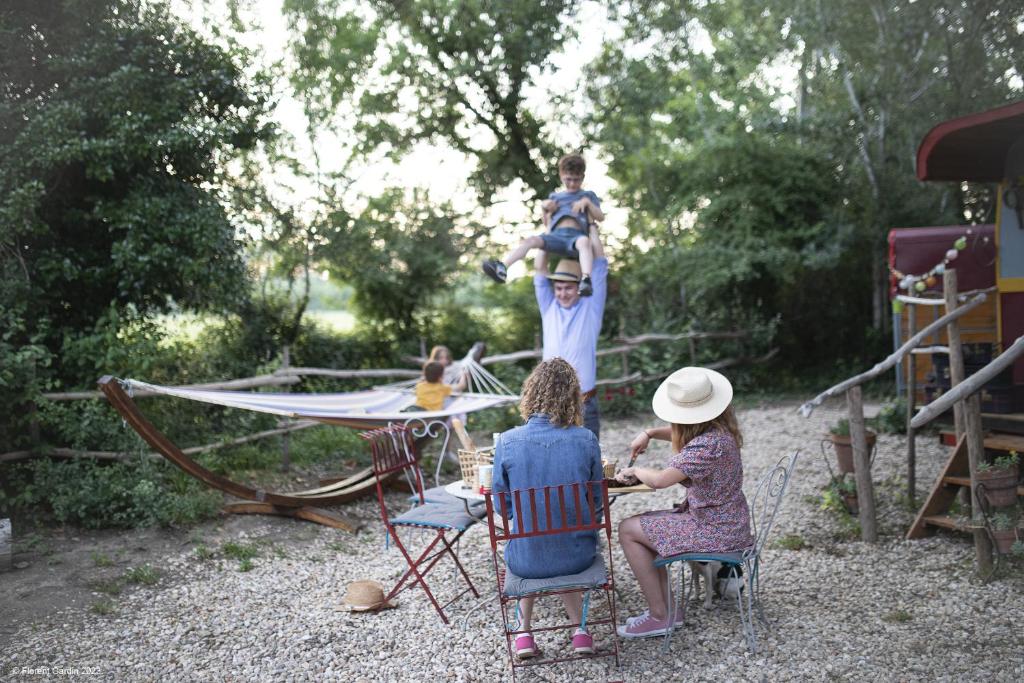 un groupe de personnes assises sur des chaises regardant un enfant sur un toboggan dans l'établissement La Roulotte Cavalière, au cœur d'une manade en Camargue, à Mas-Thibert