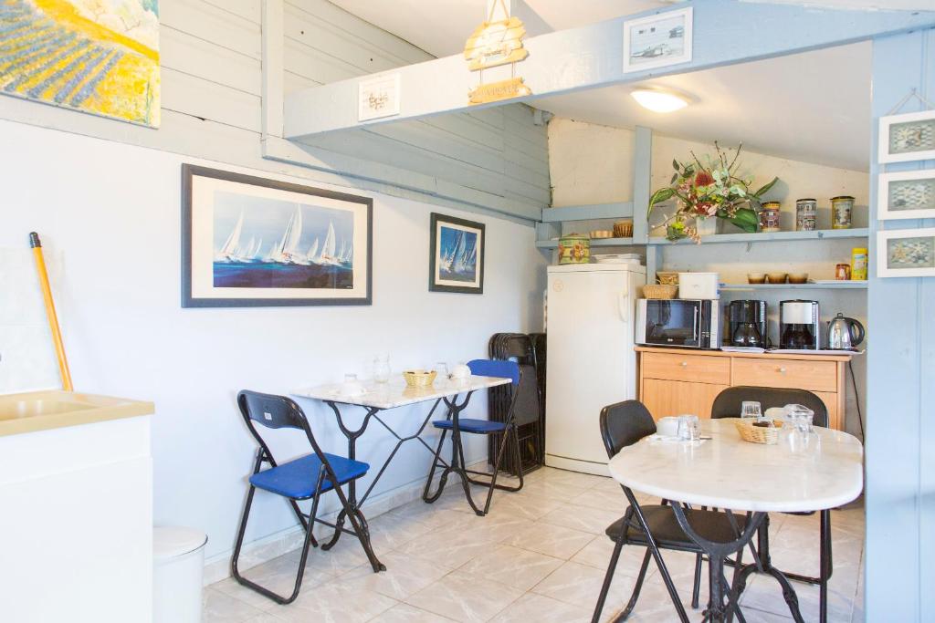 une cuisine avec deux tables et un réfrigérateur dans l'établissement Rando-Yourte, à Paluel 32 autres photos