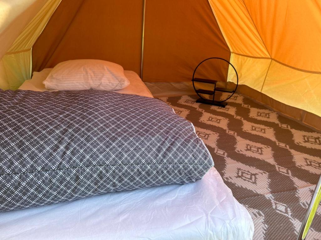 une chambre avec un lit dans une tente dans l'établissement Domaine de l'Aumône, à Cherrueix