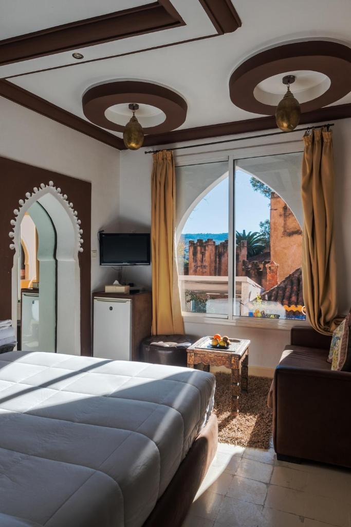 une chambre avec un lit et une grande fenêtre dans l'établissement Riad Hicham, à Chefchaouen