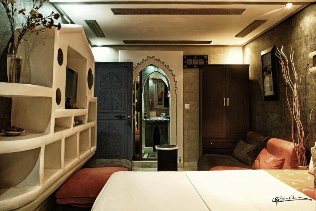 Cette chambre comprend un salon avec un canapé et une table. dans l'établissement Riad Hicham, à Chefchaouen