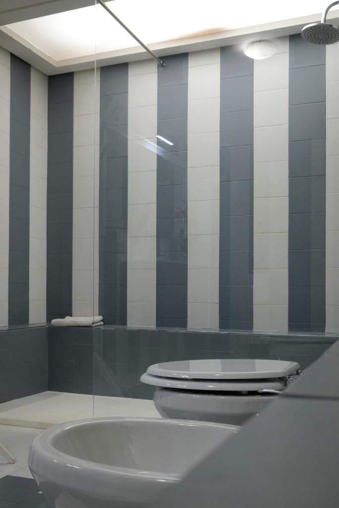 La salle de bains est pourvue de toilettes et d'une paroi en verre. dans l'établissement Sea apartment & pool 2, à Palerme